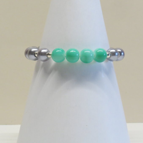 Bracelet perle de verre verte gazon vernis et sa breloque plume.
