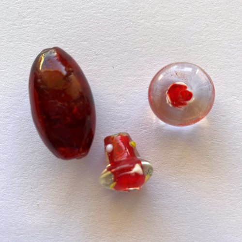 3 perles verre tons rouge et transparents formes et tailles différentes