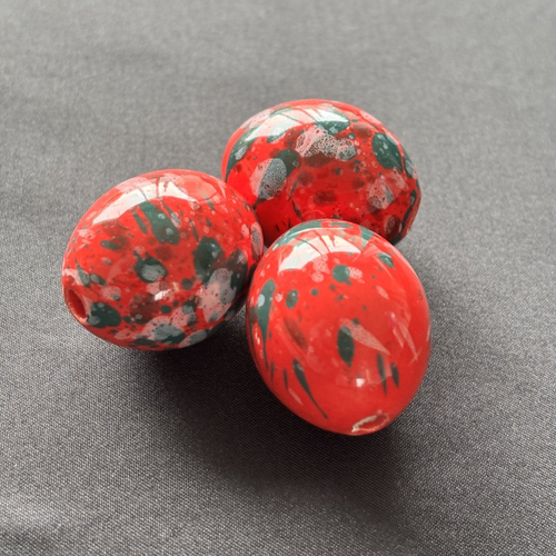 Une grande perle en céramique orange et vert  peinte à la main