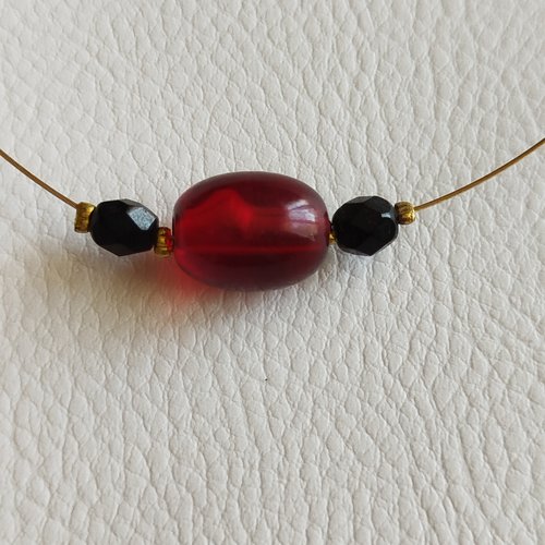 Collier sur fil câblé doré et perles centrales noire et rouge