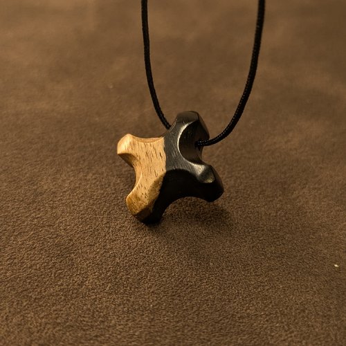 Pendentif en bois d'ébène et son aubier sculpté, avec cordon ciré