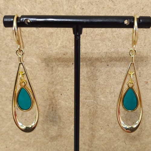 Boucles d'oreille pendentif goutte translucide bleu clair , support et pendentif ovale évidé en acier inoxydable couleur or .
