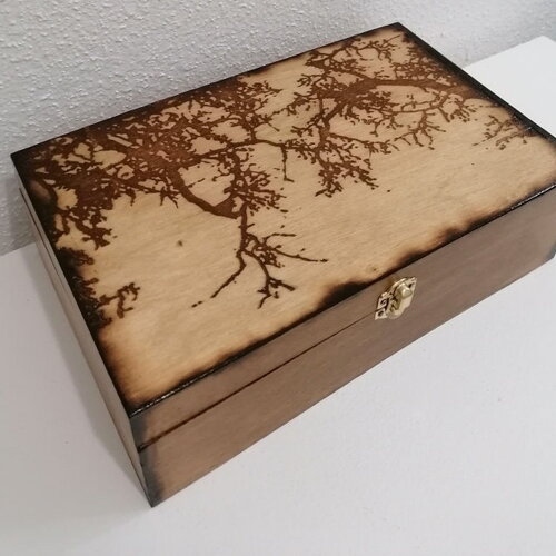 Grande boîte en bois gravée de branches sur un fond de frondaison de forêt broche bijoux pierre cristaux huiles essentielles