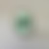 Jolie bague ovale avec décor autour cabochon en verre;noeud sur fond vert 