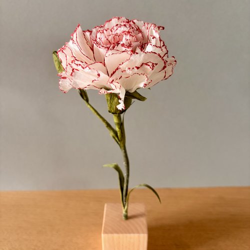 Œillet en papier crépon sur petit cube en bois