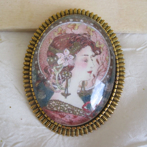 Broche en métal doré "une reproduction de mucha"