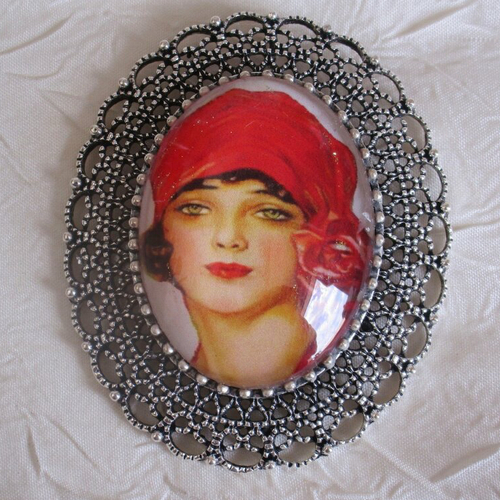 Grosse broche-pendentif en métal argenté « la femme à la coiffe rouge »