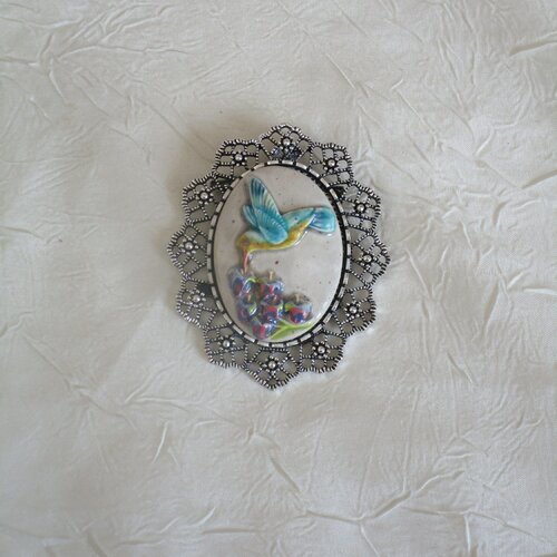 Grosse broche-pendentif en métal argenté et céramique artisanale  «un oisau picorant des fleurs »