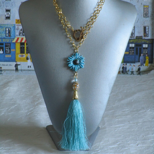 Charmant collier avec pendentif en céramique une gerbéra turquoise et un pompon