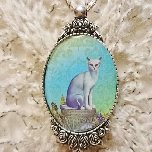Collier chat siamois assis sur un puit, chat blanc sur fond en camaïeu de vert et de bleu