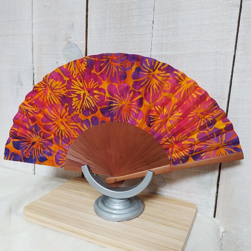 Eventail bois exotique tissu batik fleurs violettes sur fond orange