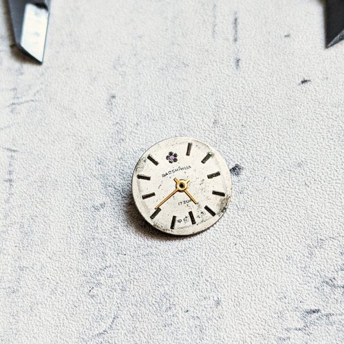 Cadran de montre rond gris aluminium et ses aiguilles dorés 17mm x1