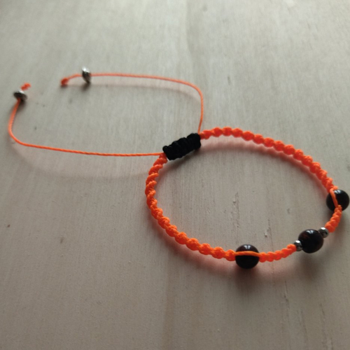 Bracelet macramé en linhasita orange vif avec des perles en oeil de  taureau - taille m ajustable