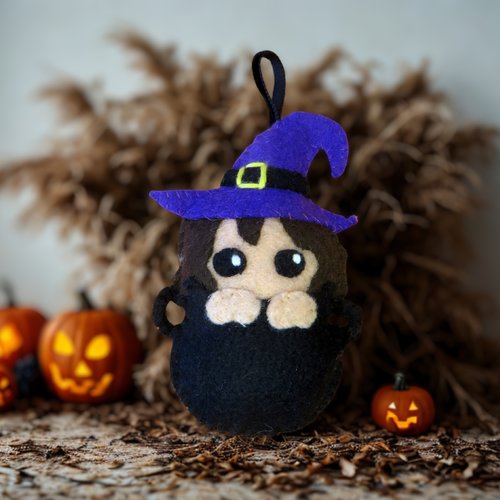 Décoration d'halloween, sorcière en feutrine dans un chaudron