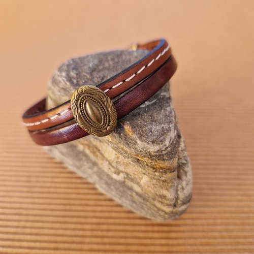 Bracelet pour femme, en cuir cousu et lisse marron, passant ovale stylisé en métal de couleur bronze