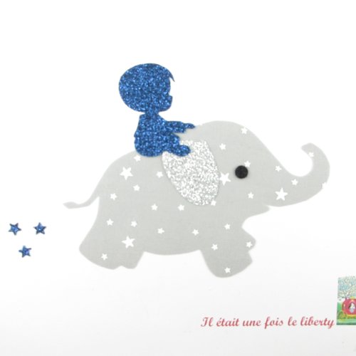 Appliqués thermocollants petit garçon sur le dos d'un éléphant en tissu gris pâle étoilé flex pailleté patch sans couture