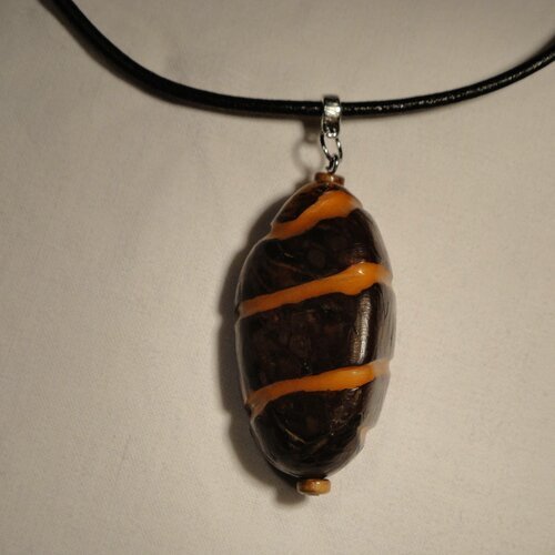 Collier avec pendentif ivoire végétal, graine entière striée orange et cordon en cuir ciré noir