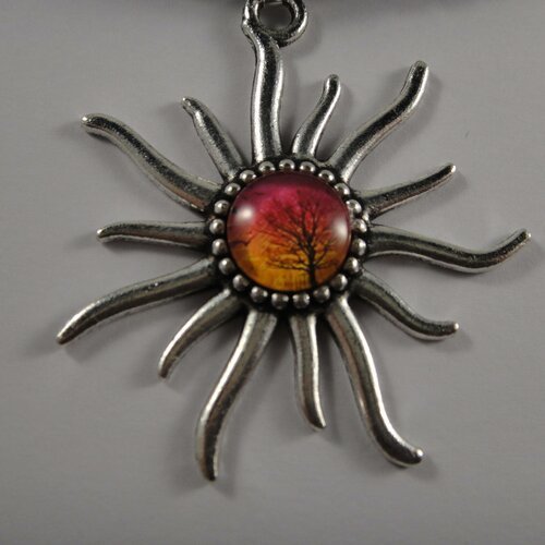 Joli collier avec pendentif en forme de soleil et au centre un cabochon en verre