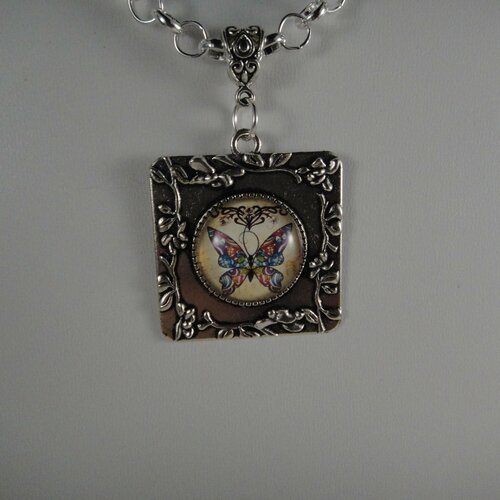 Joli collier avec pendentif un cabochon représentant un papillon très coloré et une chaîne en métal argenté 