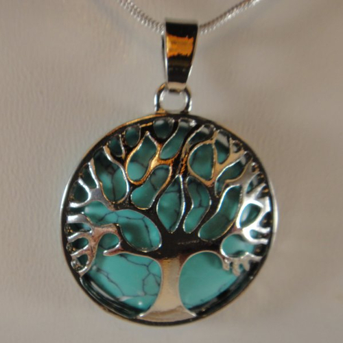Collier avec un pendentif représentant un arbre de vie en métal sur une opale bleue turquoise
