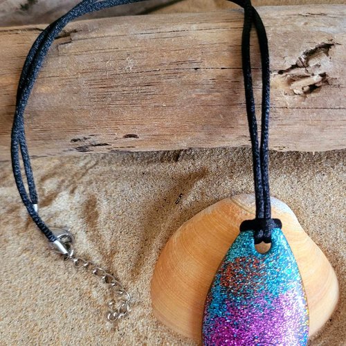 Un collier en résine avec paillettes multicolores monté sur cordon