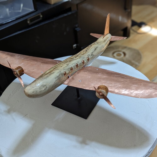 Élégance naturelle : sculpture d'avion en bois flotté aux ailes de cuivre