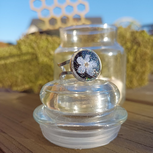 Bague fleur de myosotis séchée, fond noir, en résine uv.