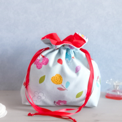 Pochon tissu fleurs multicolores bleu ciel doublé rouge – sac de rangement décoratif fait main