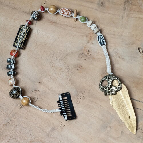 Bijou de cheveux bohème en macramé, crâne sculpté, perles artisanales et plume dorée