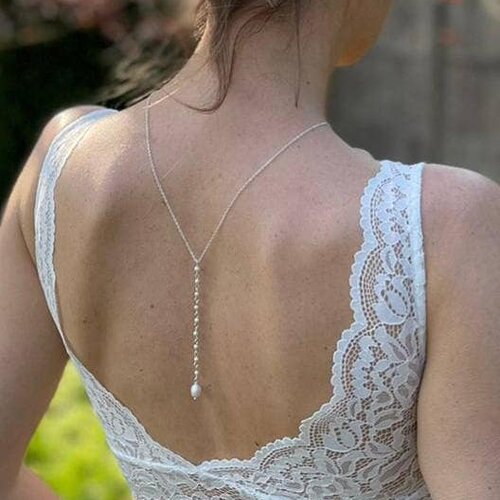 Bijou de dos délicat conçu pour compléter une robe de mariée dos nu, chaîne perlée.