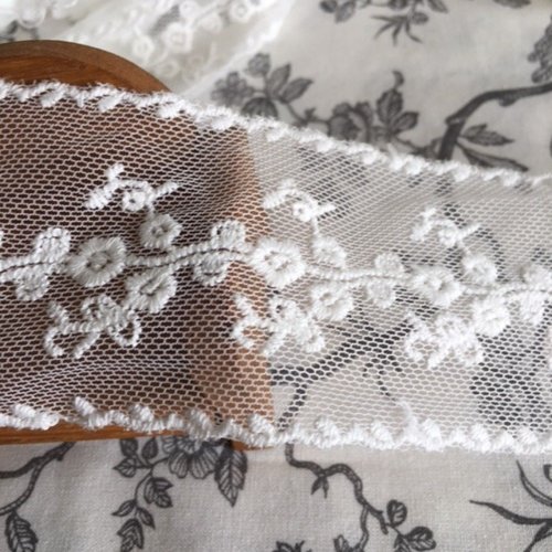 Dentelle blanc cassé, 5.5 cm de haut, tulle brodé, de chaque côté aussi, polyester et coton, neuf, au mètre