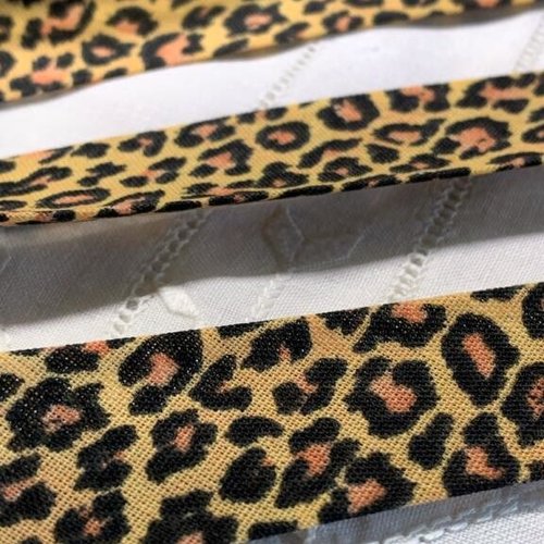 Biais replié animal, 20/10/10 mm,  moutarde, avec des pattes de tigres noires et orangées, vente au mètre
