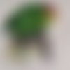 Appliqué : perroquet peint sur toile, de 15/15 cm, tout vert sur un tronc d'arbre, il mesure 10/9 cm de large, à la pièce