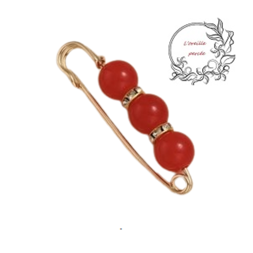 Broche épingle et ses perles rondes rouges translucides et ses rondelles strass
