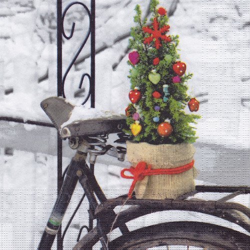 Serviette le sapin de noël sur le vélo dans le jardin sous la neige