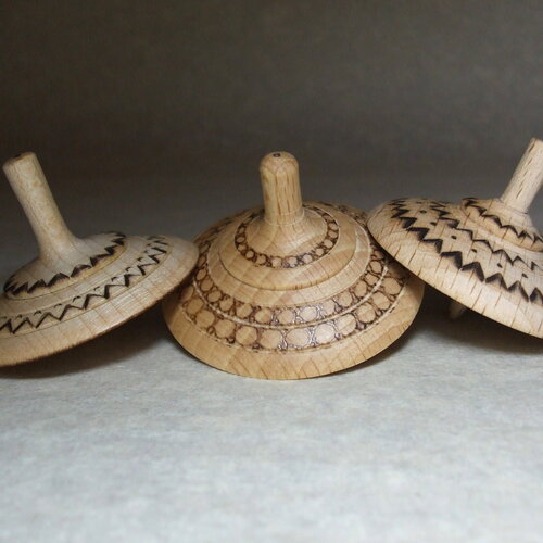 Collection de trois toupies  en bois de hêtre, fabrication manuelle, motifs géométriques noirs
