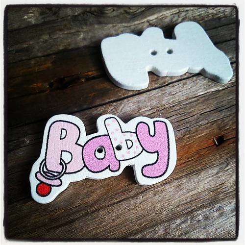 Bouton fantaisie en bois 22x36mm rose avec une tétine, inscription baby 