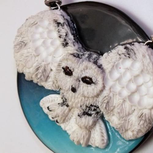 Un collier avec sa chouette en plein vol 