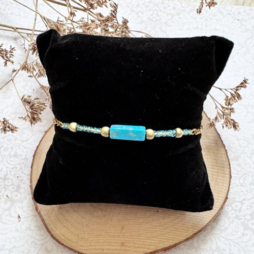 Bracelet doré et pierre bleue