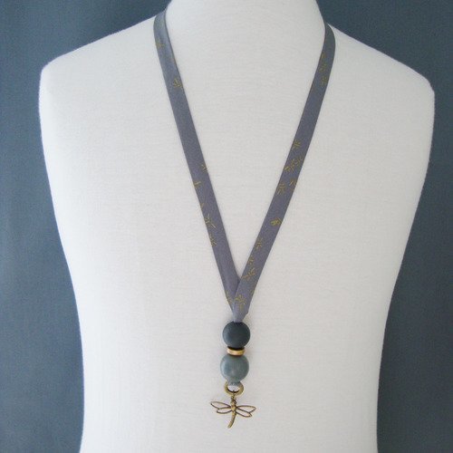 Collier en biais france duval "orageux motifs libellules dorées", perles en bois grises, pendentif libellule et fermoir en métal.