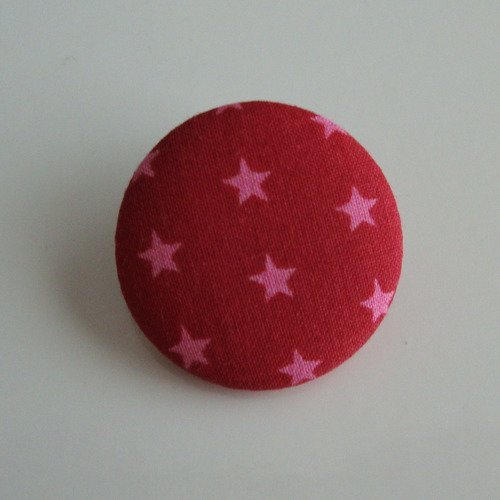 Badge recouvert de tissu frou frou rubis éclatant motifs étoiles claires. ø : 28 mm.