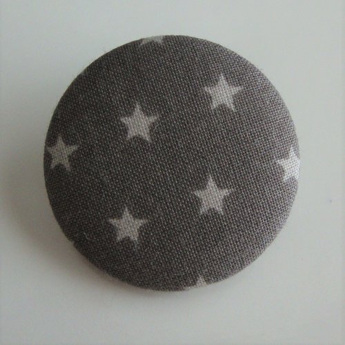 Badge recouvert de tissu frou frou "taupe foncé" motifs étoiles claires. ø : 22 mm.