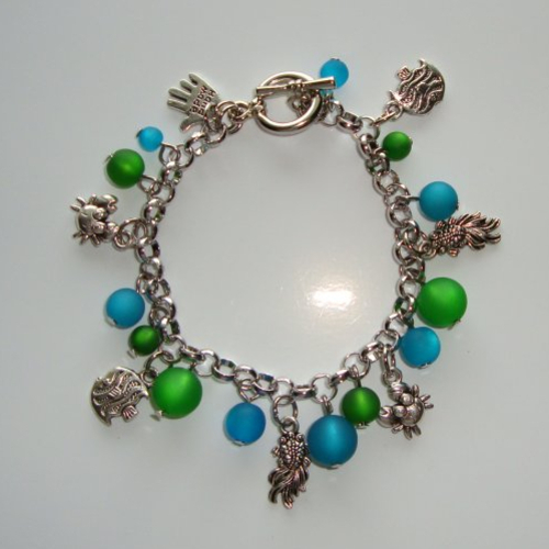 Bracelet en métal rhodié: breloques crabes et poissons, perles polaris "emerald" et "indicolite".
