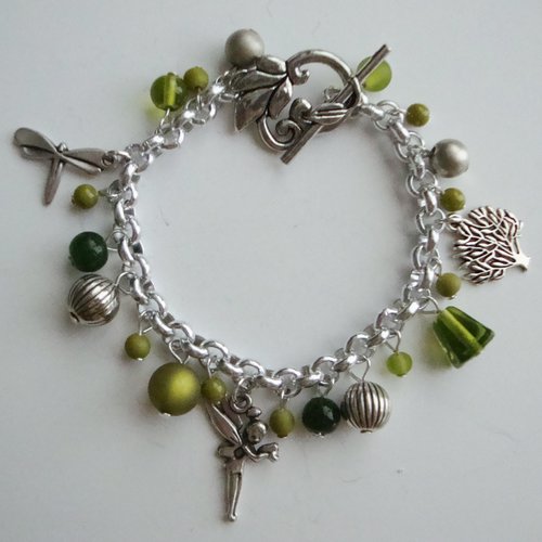 Bracelet breloques : arbre, fée, libellule, perles polaris "olivine", perles en verre pressé vert, fermoir t en forme de feuille.