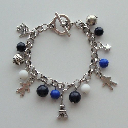 Bracelet en métal argenté : breloques tour eiffel, little girl et little boy, perles bleues, blanches, argentées.