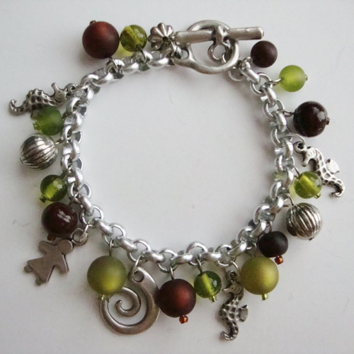 Bracelet breloques : hippocampes, little girl et spirale, perles polaris "olivine" et "marron", perles en verre pressé vert et marron.