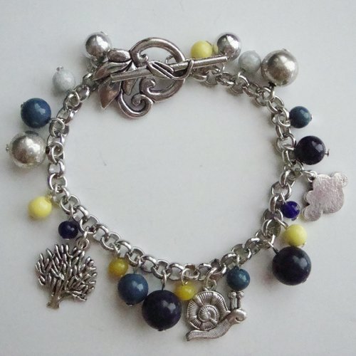 Bracelet breloques : arbre, escargot, nuage, perles polaris et perles en verre pressé bleu-jaune-argenté, fermoir t en forme de feuille.