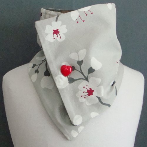 Tour de cou en drap manteau gris clair et coton imprimé cerisiers fermé par un bouton rouge en forme de cœur.