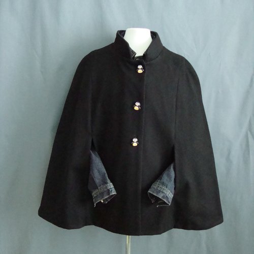 Cape à col droit en lainage noir, doublure en coton noir fermée par 3 boutons pingouin.