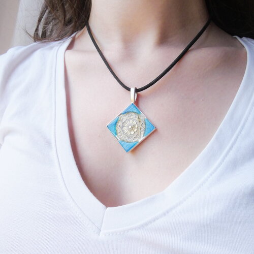Pendentif losange avec bouton vintage gravé, pâte de verre bleue irisée. bijou artisanal unique, monté sur lien en suédine.